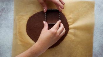 punching cookies out with a scalloped cookie cutter