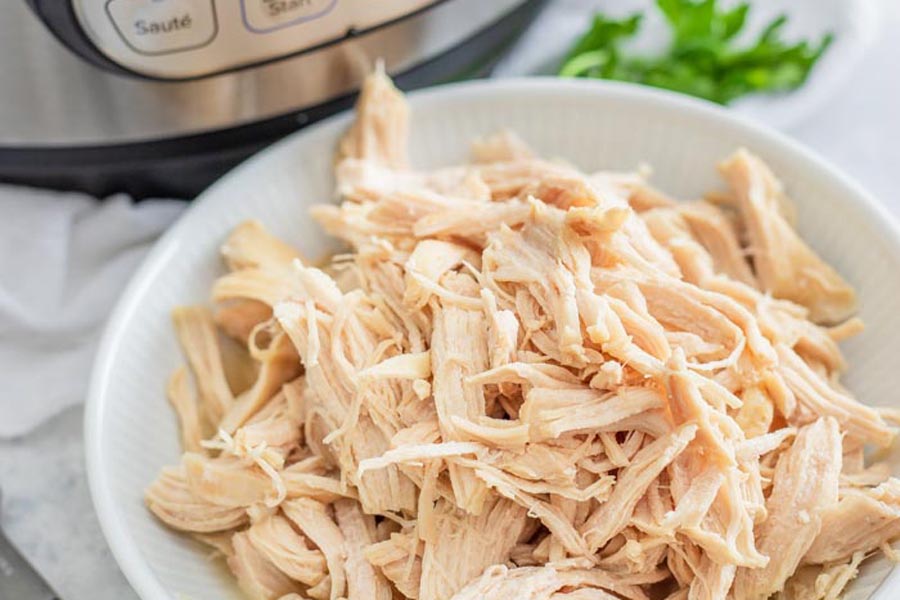 closeup of keto shredded chicken by a pressure cooker