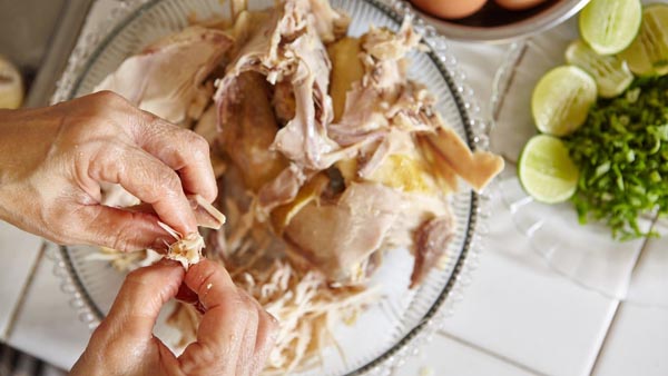 pulling apart chicken with hands