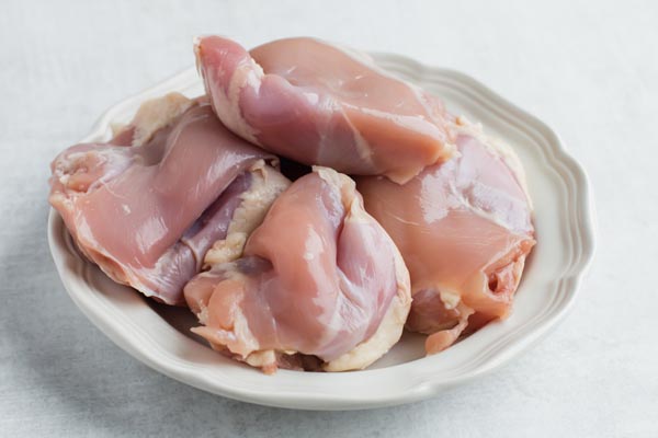a bunch of raw chicken thighs on a plate