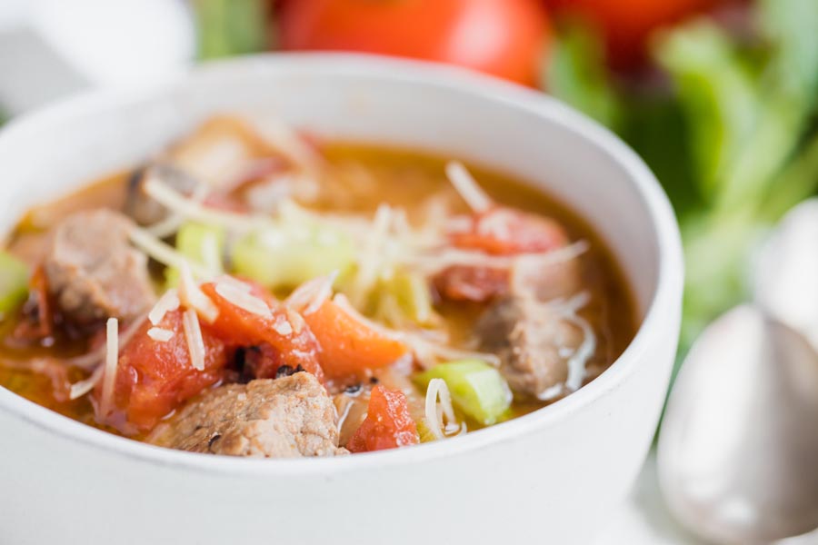 close up of tomatoes and celery and chunks of beef in a soup