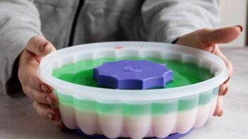 Holding a jello mold with a layered jello inside.