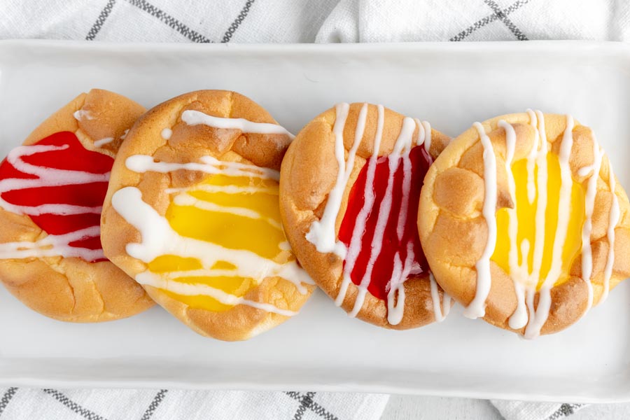 a white plate with four danishes on top