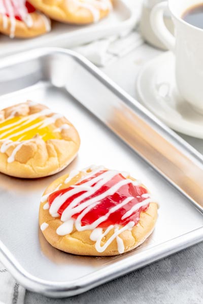 a baking tray with a red and yellow jelly danish on it