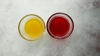 two bowls, one filled with yellow lemon jelly and the other filled with red cherry jelly