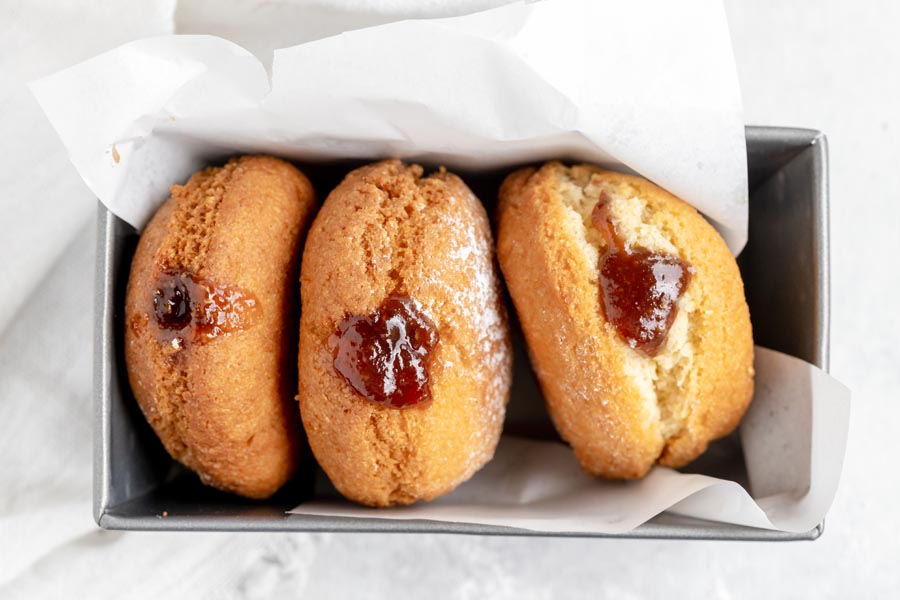 three donuts in a baking loaf pan wrapped in parchment paper