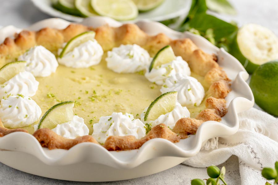 a whole lime pie in a white pie plate