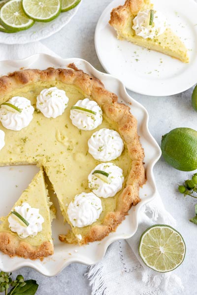 a slice of pie sits in the corner with a slice out of a pie in the pie plate with the rest of the pie