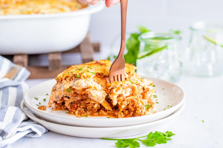 keto lasagna with layers of cheese meat and red sauce and a fork through it
