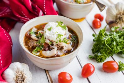 two bowls of keto lasagna soup with ricotta and mozzarella cheese on top