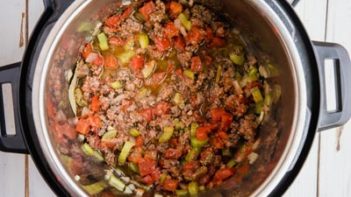 tomatoes mixed in with ground beef in a pressure cooker