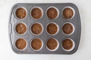 Muffin pan filled with batter and topped with a few scattered chocolate chips before baking.