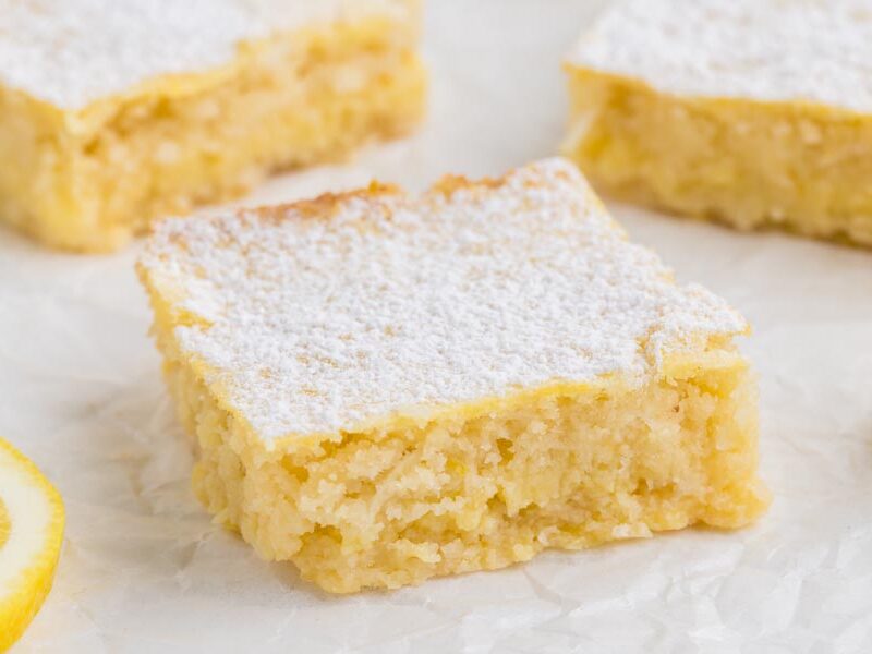 A small lemon square in front of two lemon squares.