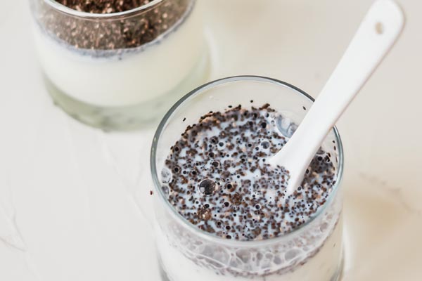 chia seeds floating on top of a glass of milk