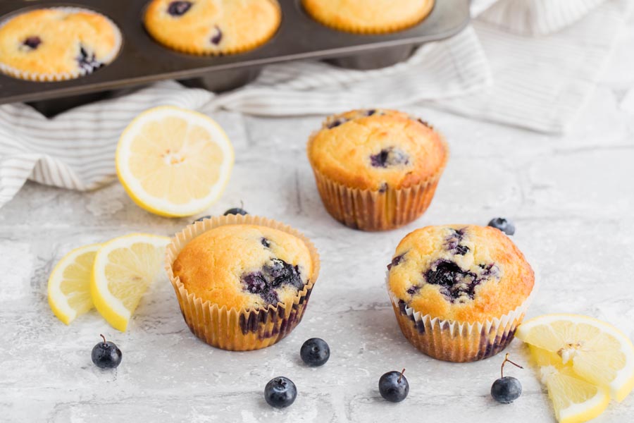 blueberry muffins in front of a muffin tin without glaze