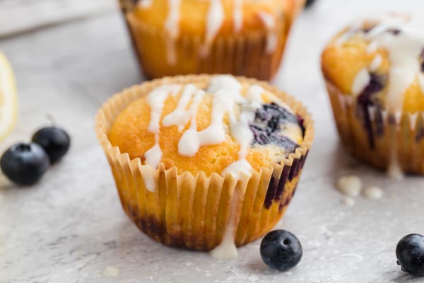 a lemon blueberry muffin with glaze dripping down