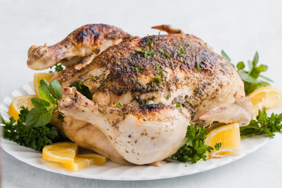 a plate of chicken with a gravy boat on the side and a side salad