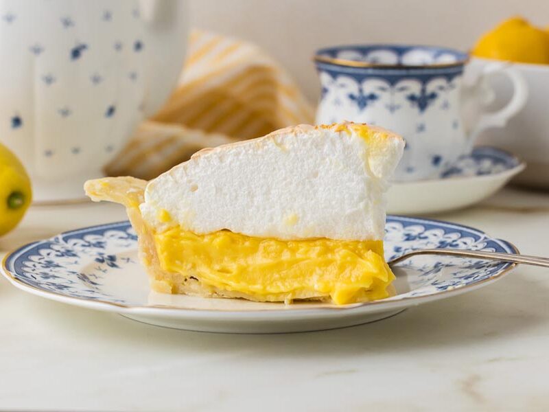 Slice of keto lemon meringue pie on a blue-and-white floral plate.