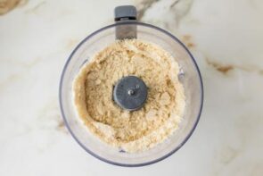 Almond flour pie crust ingredients blended in a food processor until the mixture resembles coarse crumbs.