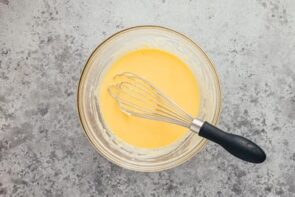 Smooth wet ingredients in a bowl with a whisk on top.