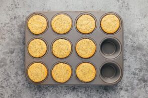 Baked lemon poppyseed muffins in a baking tray.