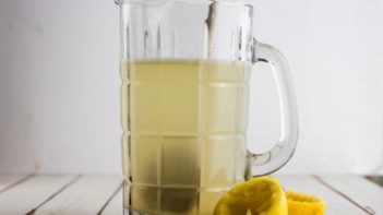 a pitcher with a spoon stirring lemonade