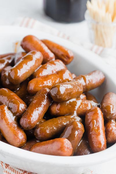 A bowl with cocktail weenies smothered in sauce.