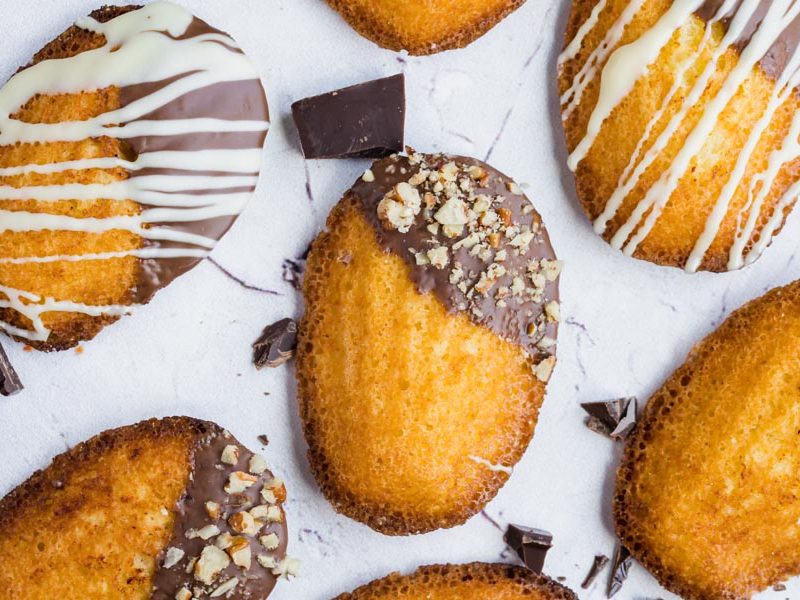 chocolate covered madeleines on a stone surface
