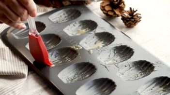 brushing butter onto a madeleine pan