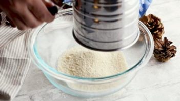sifting flours with a turn sifter in a bowl