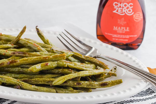 bowl of green beans coated with keto maple syrup