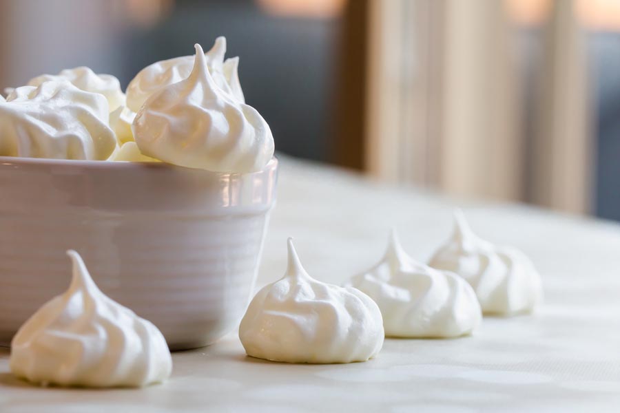meringues falling out of a white bowl