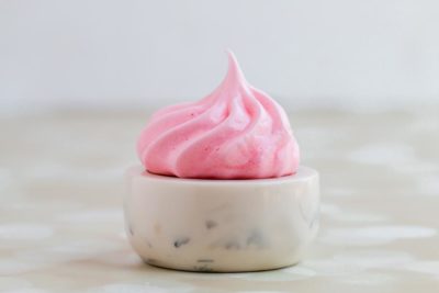 a single pink meringue on a marble bowl