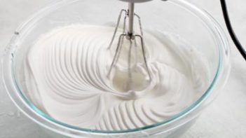 beating the meringue mixture until stiff peaks formed