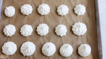 a tray of baked white meringue cookies