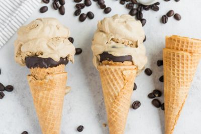 three ice cream cones filled with coffee ice cream and coffee beans around
