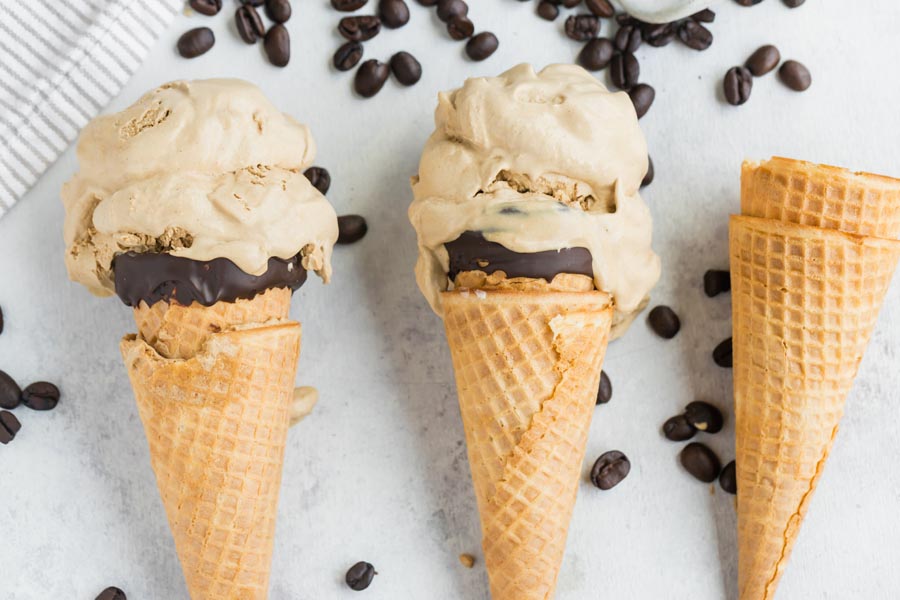 three ice cream cones filled with coffee ice cream and coffee beans around