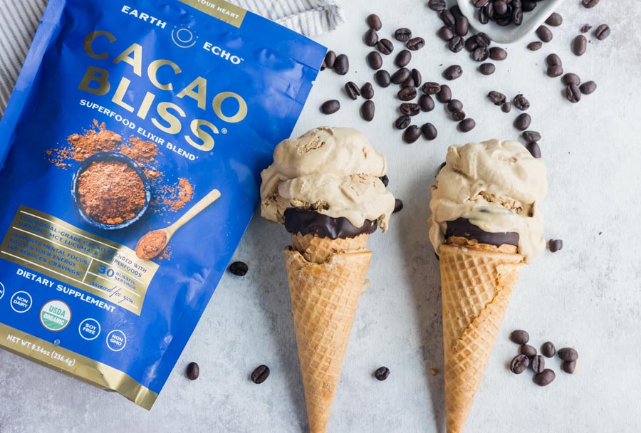 two coffee ice cream cones laying down next to a bag of cacao bliss with espresso beans spilled everywhere