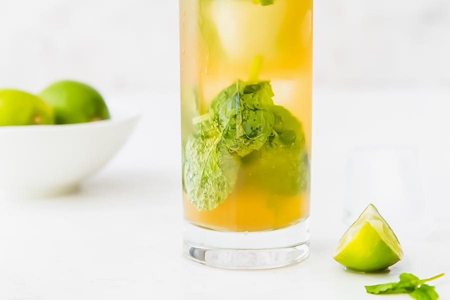 a mojito with mint leaves at the bottom of the glass