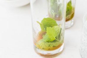 muddled mint leaves and brown sugar in a glass