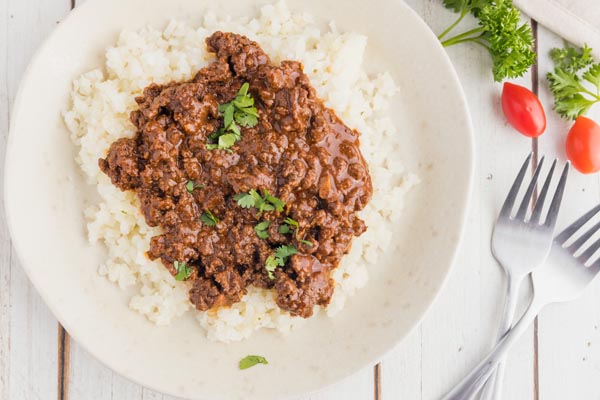 a plate with cauliflower rice and mole on top with cilantro