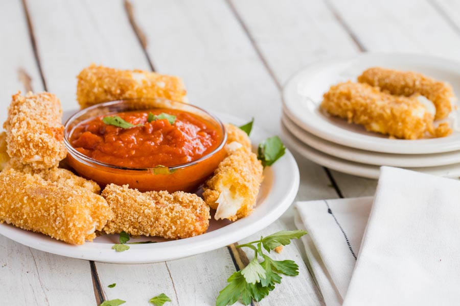 plates of cheese sticks with napkins and dipping sauce in the center