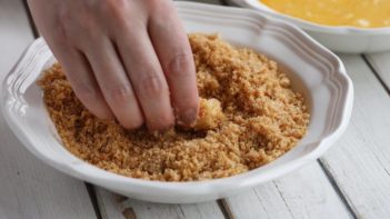 dredging cheese stick in pork panko
