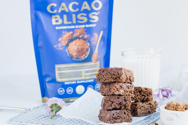 stacks of brownies on a wire rack with cacao bliss in the background and some milk