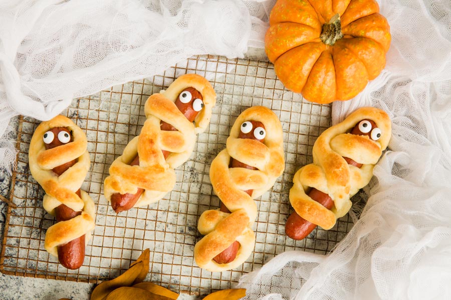 four mummies on a rusty grate with fall leaves