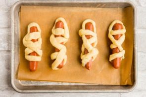 wrapped mummy hot dogs on a baking tray