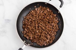 Seasoned ground beef in a non-stick skillet.