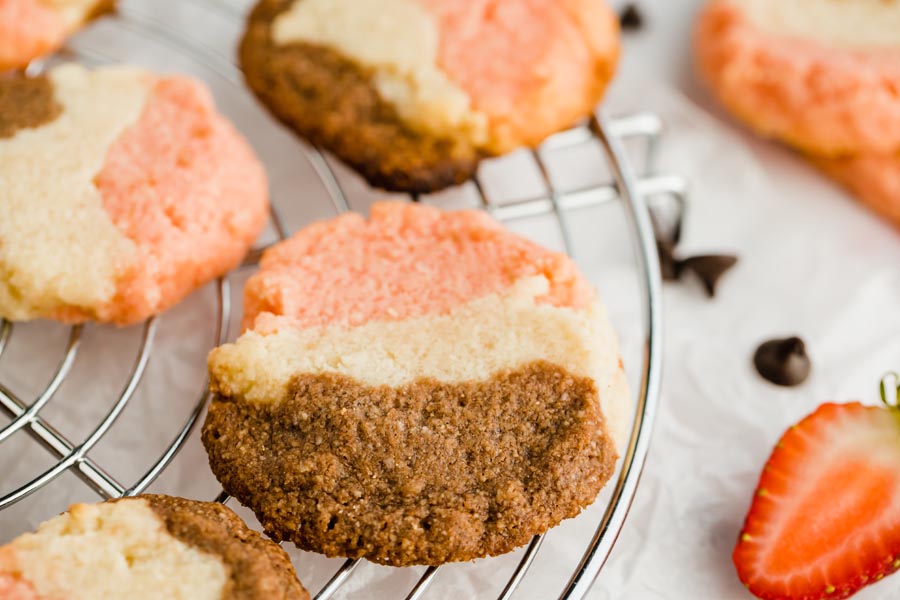 close up of a keto neapolitan cookie on a wire rack with more cookies next to it