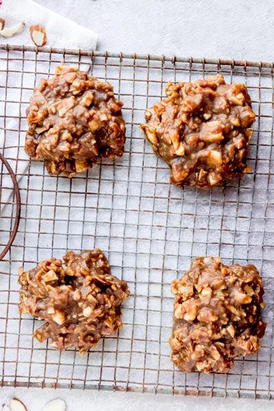 Four chocolate cookies on a wire cooling rack.