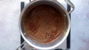 A saucepan with a chocolate sauce inside.